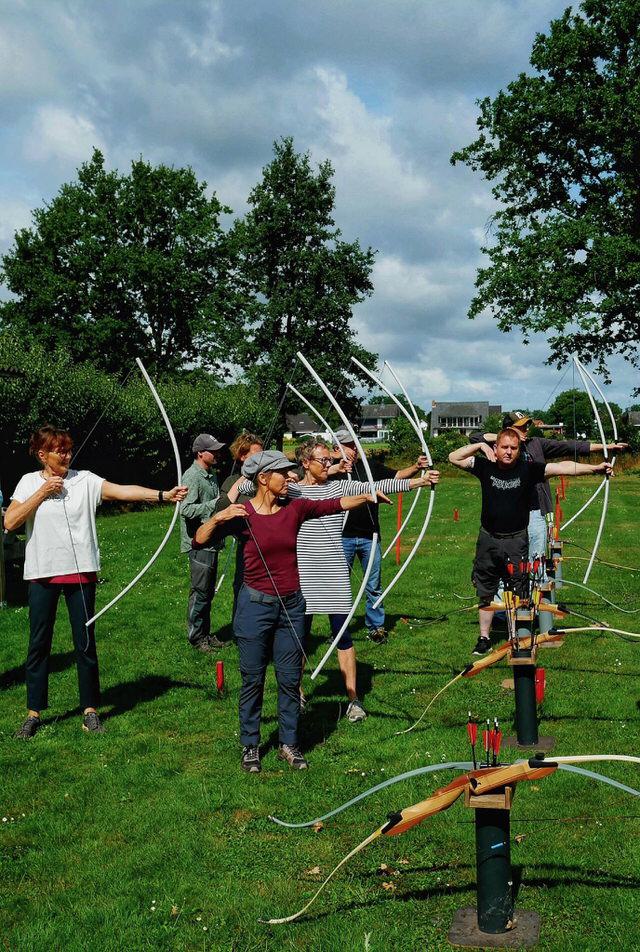 Gruppe Bogenschützinnen mit Übungsbögen